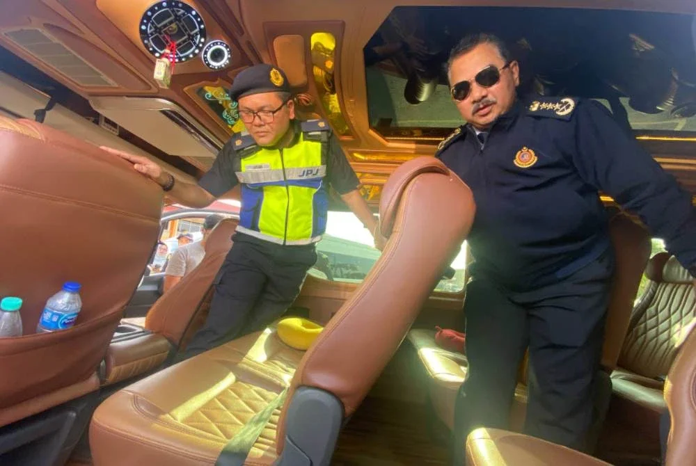 Muhammad Kifli (kanan) menunjukkan sebuah van boleh membawa lapan hingga 10 penumpang dalam satu masa yang mana bayaran yang dikenakan sekitar RM70 hingga RM150 seorang. Foto Sinar Harian/Hazelen Liana Kamarudin