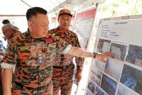 Muhammad Al Mustakim menunjukkan kawasan kebakaran tanah gambut yang sudah berjaya dipadamkan.