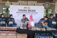 Ismail (tengah) menunjukkan guni berisi ganja serta gabus yang digunakan sindiket pada sidang akhbar di Kompleks Kastam Perlis, Kangar.