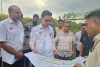 Mohammed Taufiq (dua dari kiri) melihat pelan projek pembinaan Perak Youth Center ketika lawatan kerjanya di Tambun pada Rabu.