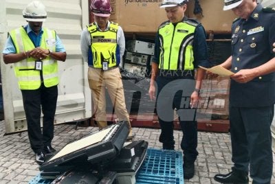 Nik Ezanee (dua dari kiri) melihat antara barangan dirampas menerusi sitaan kontena dalam operasi yang dijalankan pada Selasa