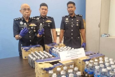 Ahmad Sukarno menunjukkan ubat batuk dan dadah yang dirampas.