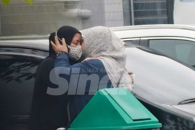 Kelihatan dua wanita saling berpelukan.