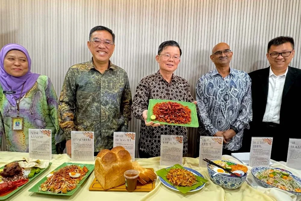 Kon Yeow (tengah) menunjukkan sampel antara makanan yang diluluskan pewartaan sebagai Warisan Negeri ketika sidang media di pejabatnya di Komtar pada Khamis.