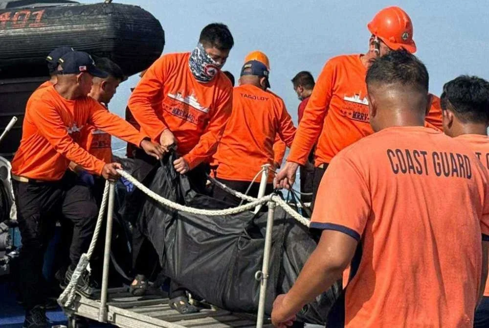 Anggota Pengawal Pantai Filipina membawa beg mayat. Foto AP