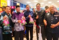 Azmin (tengah) menunjukkan ayam yang ditawarkan pada harga promosi sempena pembukaan Mydin Gurun.