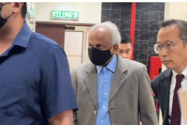 Tertuduh (tengah) diiringi peguamnya ketika hadir ke Mahkamah Butterworth pada Khamis.