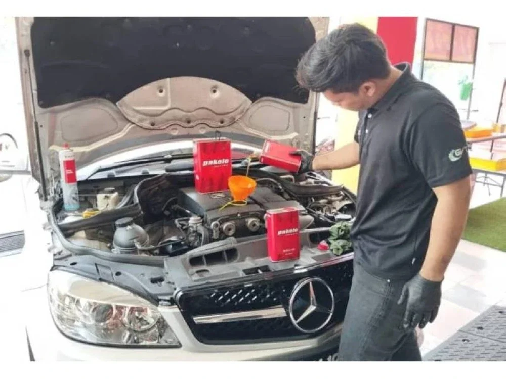 Mohamad Shafiq membantu menyelenggara kenderaan pelanggan di salah sebuah premis miliknya di Ipoh. 