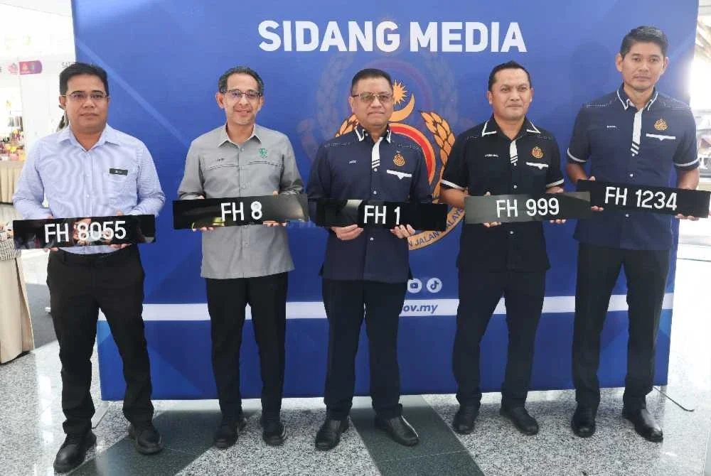 Aedy Fadly (tengah) menunjukkan nombor pendaftaran FH pada Majlis Pelancaran Nombor Pendaftaran Istimewa Siri FH Sempena Hari Wilayah Persekutuan di Auditorium Tun Azizan Zainul Abidin, Perbadanan Putrajaya hari ini. - Foto: Bernama
