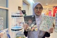 Wan Nurulamni menunjukkan corak terbaharu al-Quran Organizer Mu'jam (A02) yang dijual sepanjang Karangkraf Ramadan Bookfest.