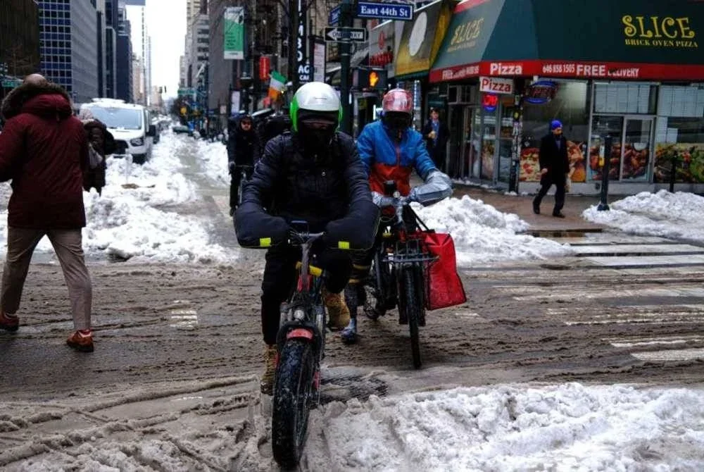 Beberapa lelaki menghantar makanan dengan basikal di Third Avenue, Manhattan, New York City.