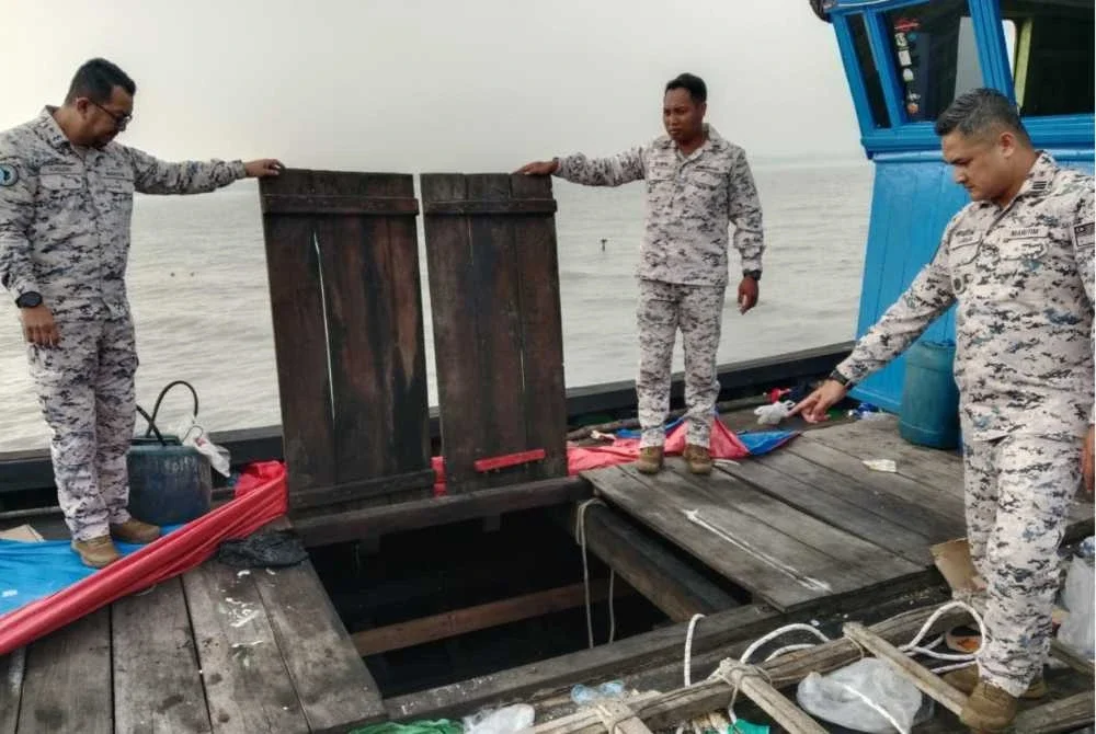 Mohd Fairusnizam (kanan) menunjukkan keadaan bot pom-pom yang ditahan pihaknya.