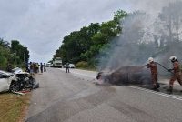 Anggota bomba memadamkan kebakaran kereta Persona selepas terlibat dalam kemalangan empat kenderaan di Kilometer 43, sempadan Mersing. - Foto JBPM Johor