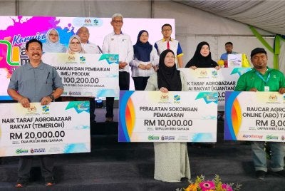 Aminuddin (tengah) bersama usahawan penerima bantuan dan insentif FAMA.