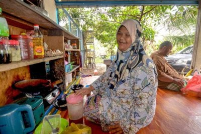 Mohd Nor Hisham dan Zuriana yang menghidap penyakit kronik memasak di bahagian anjung hadapan rumah mereka di Kampung Bukit Jeruk, Jabi, di Jertih berikutan masalah kesihatan yang dihadapi. Foto Bernama 