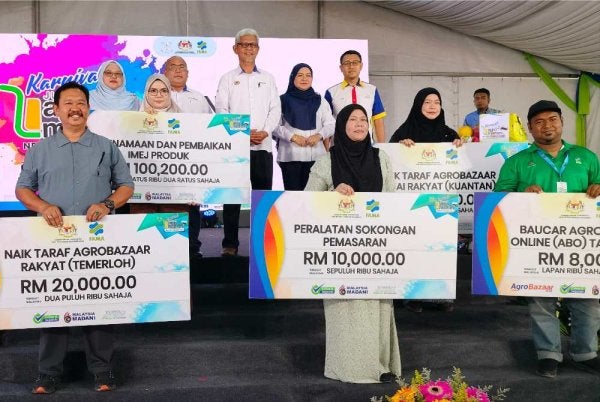 Aminuddin (tengah) bersama usahawan penerima bantuan dan insentif FAMA.