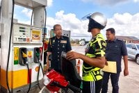 Azman (kiri) melihat seorang pengguna menikmati kemudahan BUDI95 semasa sesi lawatan kerja beliau di sebuah stesen minyak di Rantau Panjang pada Ahad.Foto Sinar Harian/Hazelen Liana Kamarudin