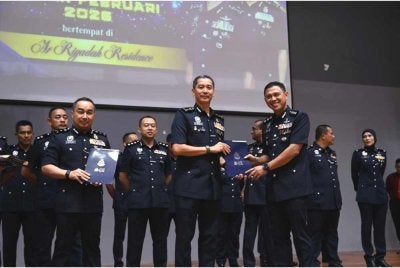 Mohd Khairi (tengah) menyampaikan sijil penghargaan sempena Perhimpunan Bulanan Ketua Polis Terengganu di Kuala Nerus pada Ahad.
