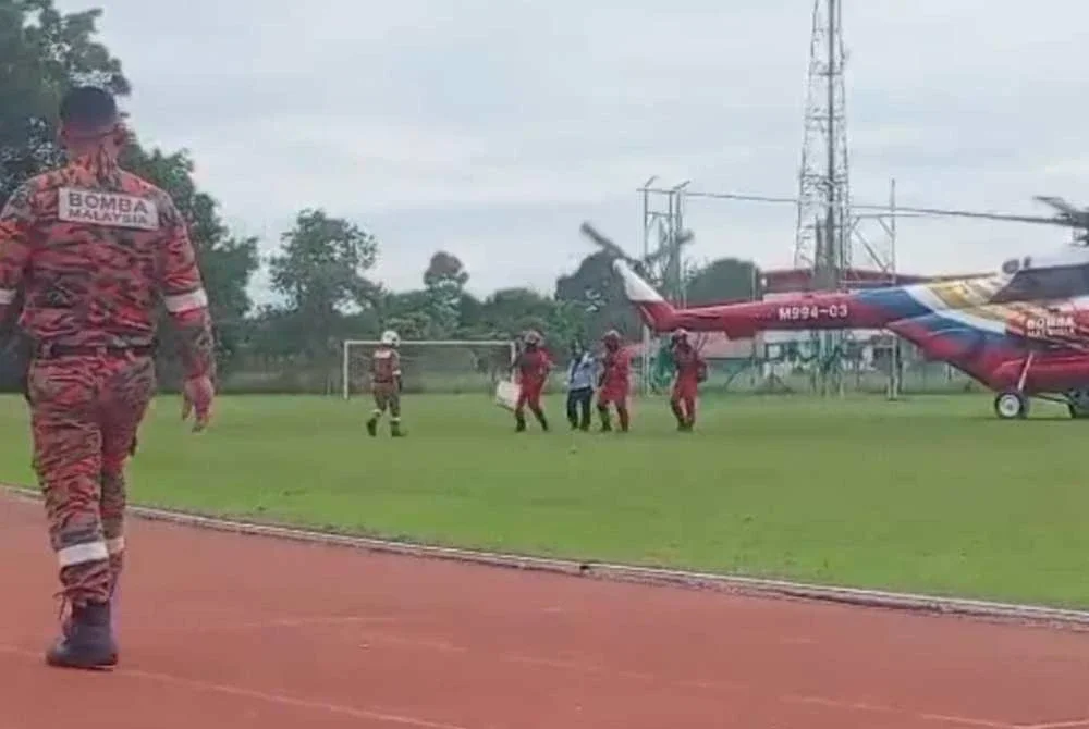 Wanita sarat mengandung dibawa menaiki helikopter untuk keluar dari Paitan ke Beluran.