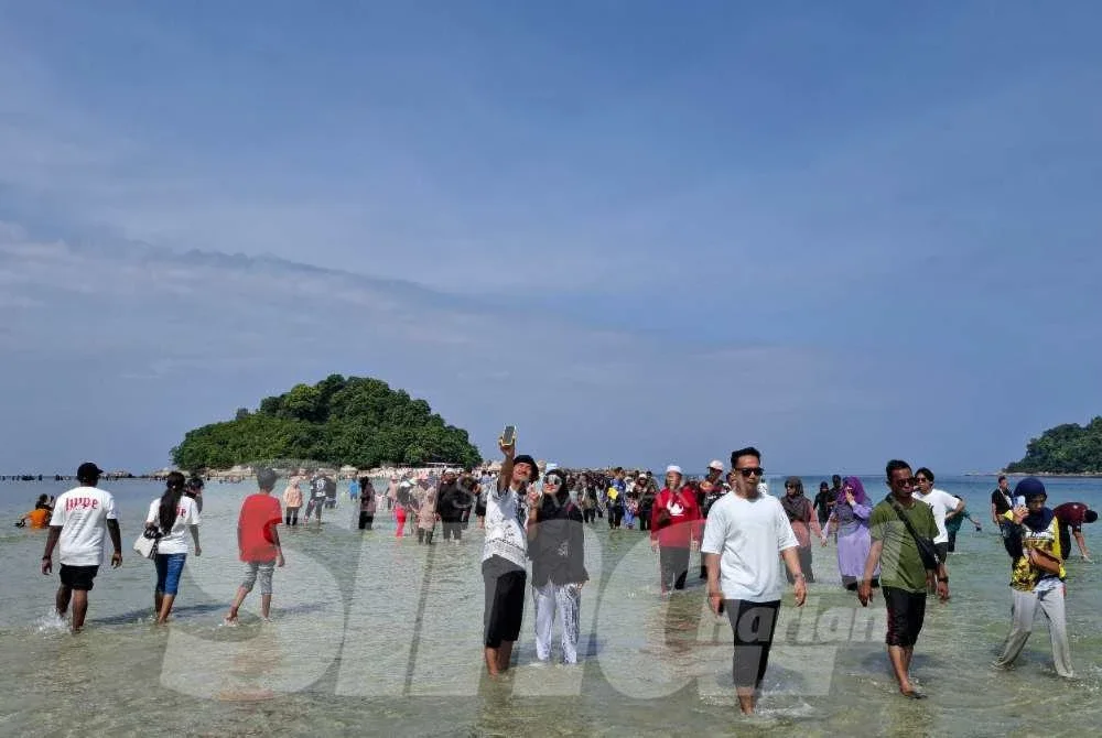 Pembentukan 'laut terbelah' itu membolehkan pengunjung berjalan kaki sepanjang 400 meter di atas beting pasir di Coral Beach, Teluk Nipah ke Pulau Giam.