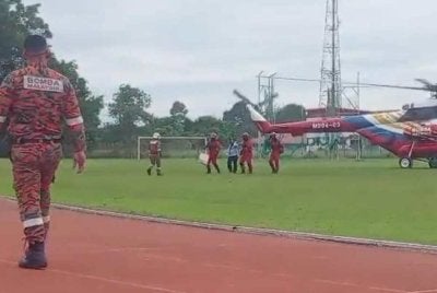 Wanita sarat mengandung dibawa menaiki helikopter untuk keluar dari Paitan ke Beluran.