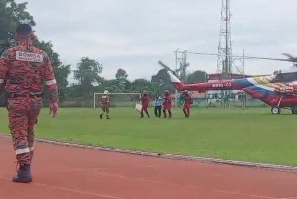 Wanita sarat mengandung dibawa menaiki helikopter untuk keluar dari Paitan ke Beluran.