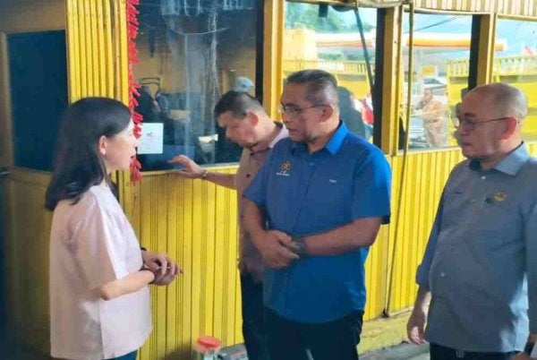 Takiyuddin (dua dari kanan) melawat ke gudang terbakar di Jalan Kebun Sultan. 