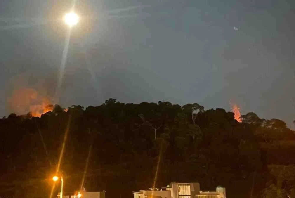Satu kebakaran berlaku di kawasan hutan dianggarkan seluas 0.8 hektar di puncak bukit berhampiran sebuah apartmen di Taman Tun Abdul Razak, malam ini. Foto Bernama