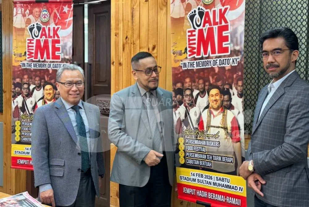 Tengku Mohamed Faziharudean (tengah) menunjukkan gegantung Walkathon D’Raja.