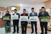Zamri (tengah) bersama Syamsul Hazeman (dua dari kanan) dan Ahmad Nazim (dua dari kiri) menunjukkan plakad kadar zakat fitrah di Perak untuk tahun 1447 Hijrah bersamaan 2026 Masihi bagi setiap individu selepas sidang media berkenaan.