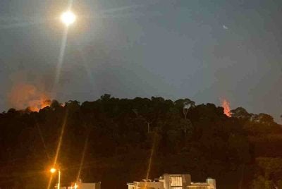 Satu kebakaran berlaku di kawasan hutan dianggarkan seluas 0.8 hektar di puncak bukit berhampiran sebuah apartmen di Taman Tun Abdul Razak, malam ini. Foto Bernama