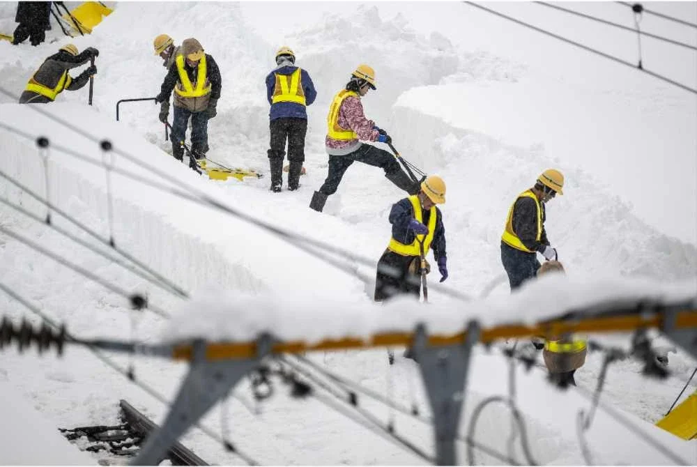 Kakitangan membersihkan landasan kereta api yang diselimuti salji di stesen Shin Aomori. - Foto: AFP