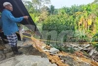 Abdul Hamid menunjukkan keadaan cerun runtuh menjejaskan empat rumah termasuk rumahnya di Kota Perdana, Pekan.