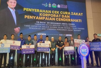 Mohamad (tujuh dari kiri) menerima replika cek dari Pengarah Urusan Nasmir Holding, Datuk Kadhar Shah Abdul Razak pada Majlis Citra Korporat dan Pelancaran Pusat Pendidikan Sheikh Abdul Fahim Negeri Pulau Pinang pada Selasa.