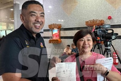 Kim Choo (kanan) menunjukkan penukaran alamat demi mengundi YB Helmy (kiri) untuk PRN Melaka dijadualkan berlangsung tahun ini.