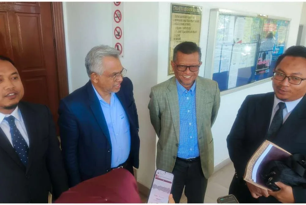 Mohd Daud (dua kiri) dan Muhamad (dua kanan) selepas selesai prosiding di Mahkamah Sesyen Alor Setar pada Khamis.