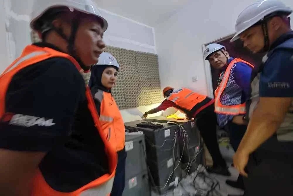 Mohd Noor Helmy (dua kanan) melihat mesin bitcoin yang terdapat pada rumah kosong berkenaan.