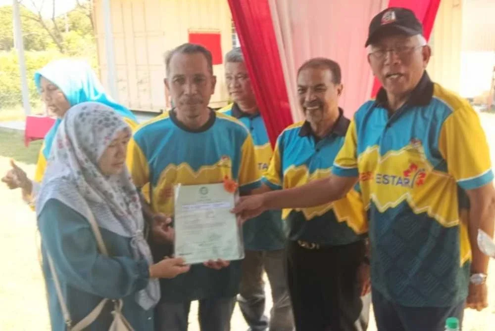 Mahdzir (kanan) menyerahkan geran hak milik Desa Keda Sungai Udang, Yan kepada salah seorang penerima.