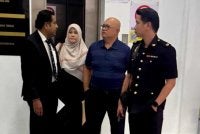 Ismaidi (dua dari kanan) ketika hadir ke Mahkamah Labuan.