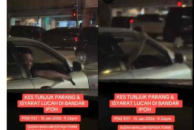 Tangkap layar video tular memaparkan seorang lelaki memegang parang serta menunjukkan isyarat tidak sopan dalam kejadian di Pekan Baru, Ipoh.