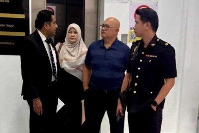 Ismaidi (dua dari kanan) ketika hadir ke Mahkamah Labuan.