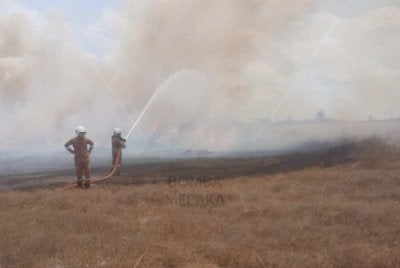 Bomba memadamkan kebakaran di lbelukar seluas 3.2 hektar di Kota Syahbandar, Melaka pada Khamis. FOTO: JBPM Melaka.