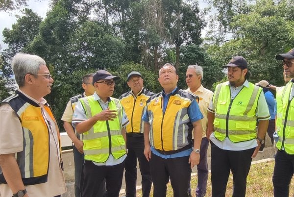 Marhalim (dua dari kiri) memberi penerangan kepada Alexander (tengah) pada Majlis Penyerahan Pembaikan Cerun Laluan VHF Telapak Buruk di Dataran Bukit Tangga, Jelebu, Negeri Sembilan.