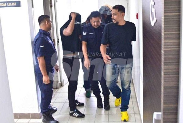 Alfadli (kanan) bersama beberapa lagi tertuduh ketika dihadapkan di Mahkamah Majistret Kuala Terengganu atas kesalahan mengeluarkan kata-kata kurang sopan dan membakar suar di dataran Jambatan Angkat, Kuala Terengganu pada Ahad lalu. 