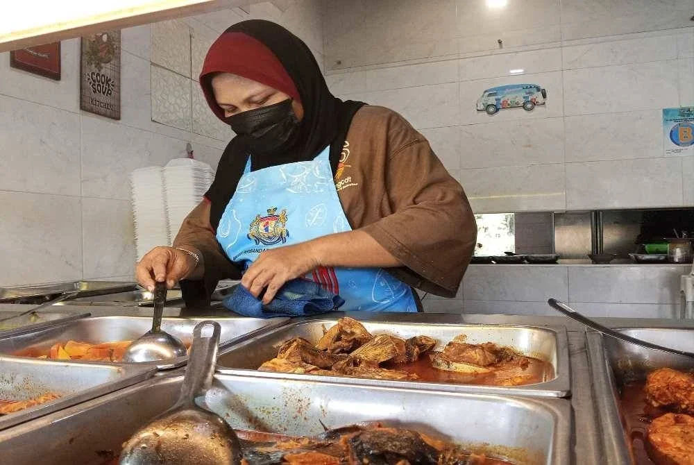 Rahayu menjalankan perniagaan gerai makan seperti biasa. 