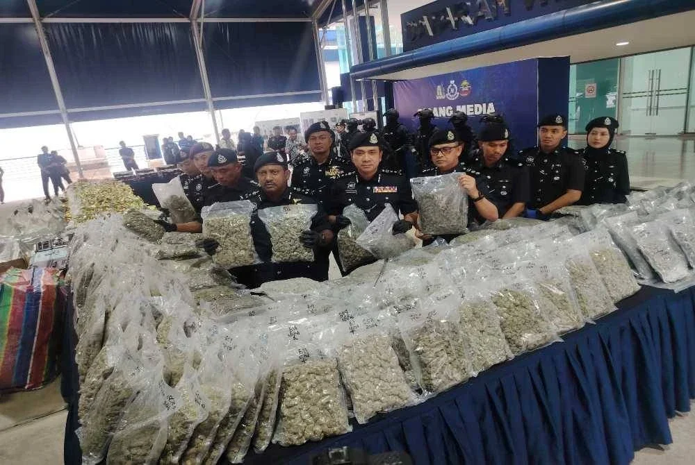 Hussein (tengah) menunjukkan dadah bunga ganja yang dirampas polis baru-baru ini.