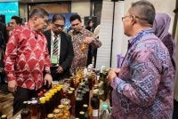 Mohamad (kiri) melihat produk yang dipamerkan sempena majlis Anugerah Kecemerlangan Agro Madani dengan diiringi Fazrul Nizam (dua dari kiri). Foto MySKALA
