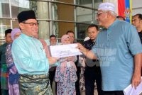 Syed Hasan (kanan) menyerahkan memorandum kepada Mohd Azam yang mewakili Fadhlina di lobi KPM, pada Jumaat.