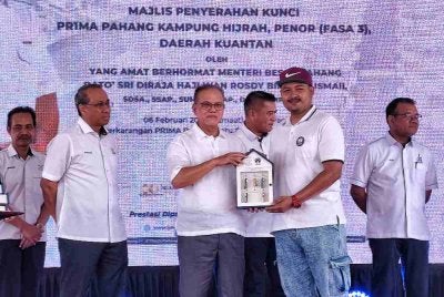 Wan Rosdy menyerahkan kunci kepada salah seorang penerima pada majlis penyerahan pemilikan Perumahan Rakyat 1Malaysia (PR1MA) Pahang Batu 6, Lepar (Fasa 1 dan 2) dan majlis penyerahan kunci PR1MA Pahang Kampung Hijrah, Penor, pada Jumaat.