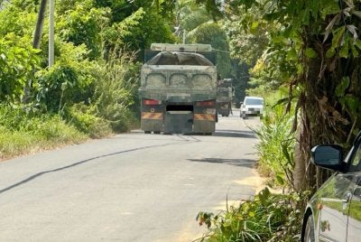 Kereta yang perlu berhenti kerana berselisih dengan lori di laluan sempit.